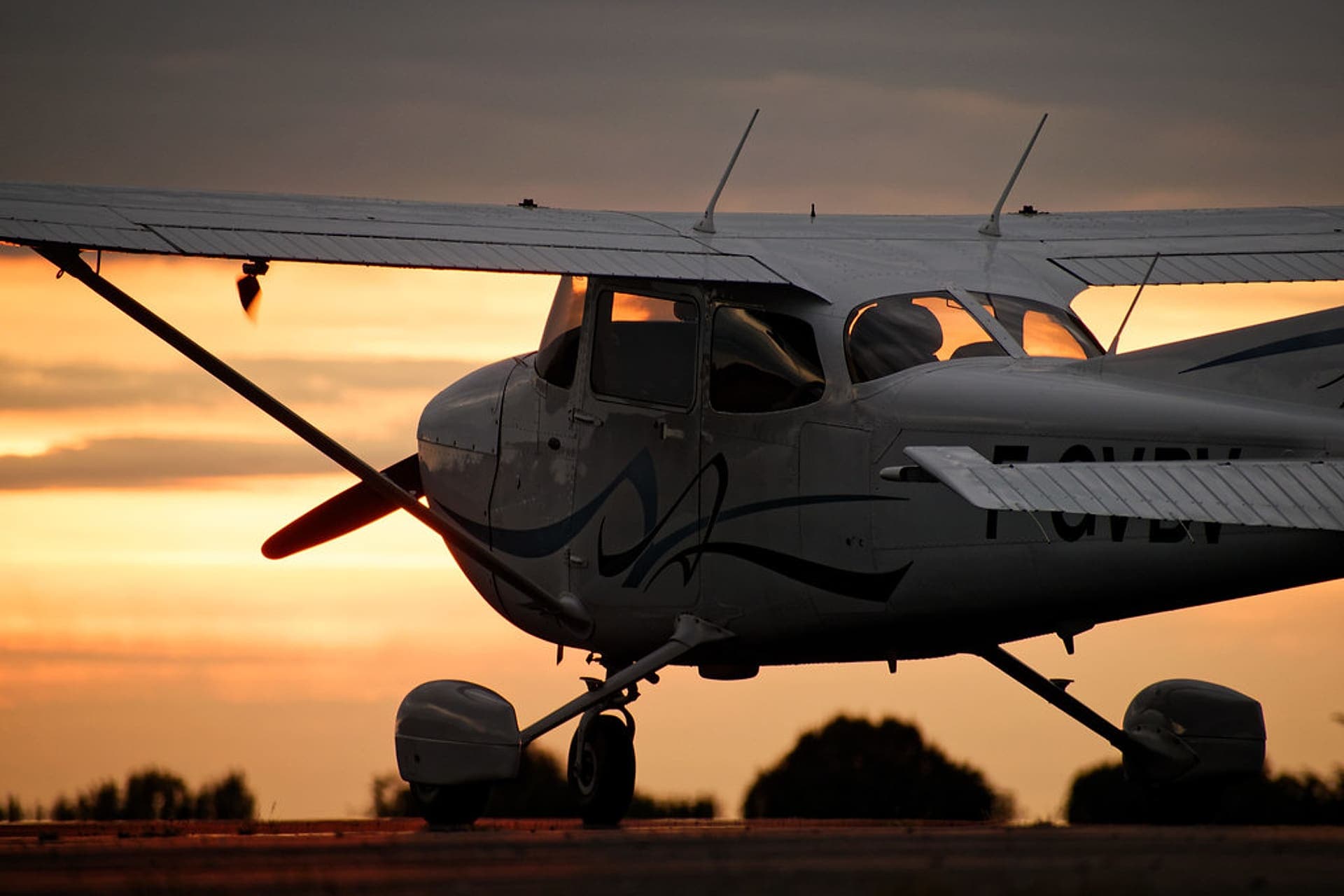 Cessna 172 training airplane parked on an airport ramp at sunset